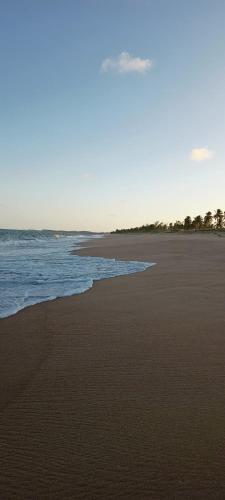 a sandy beach with the ocean in the background at Chalé Barra Sirinhaém in Sirinhaém