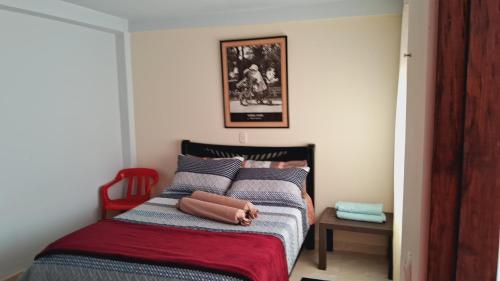 1 dormitorio con 1 cama con silla roja en Parcela Campestre, en Piedecuesta