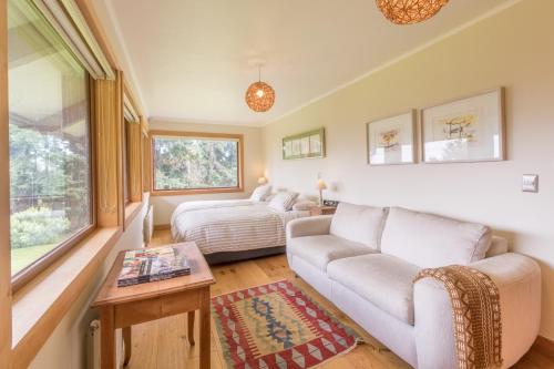 a living room with a couch and a bed at B&B Puerto Varas Playa Venado in Puerto Varas