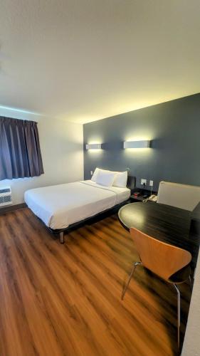 a hotel room with a bed and a desk and a chair at Econo Lodge in Idaho Falls