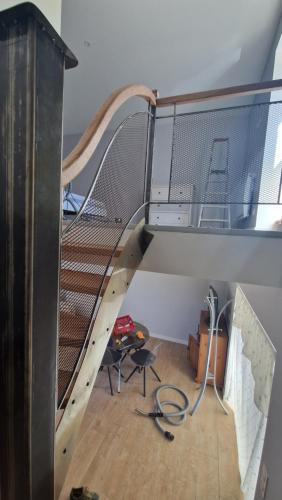 uma escada de madeira com um corrimão de metal num quarto em jolie petite maison 134 lugan em Lugan