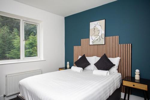 a bedroom with a large bed with blue walls at The Burnopfield in Burnopfield