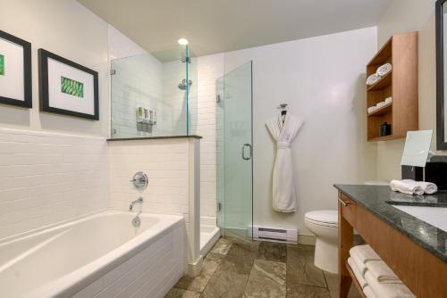 a bathroom with a bath tub and a toilet at Oswego Hotel in Victoria