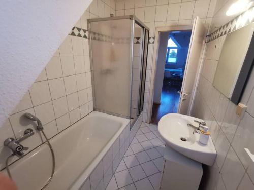 a bathroom with a shower and a sink and a tub at Helle Maisonnette Wohnung Penthouse in Recklinghausen