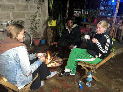 a group of people sitting around a fire at Meleji Studio House in Arusha