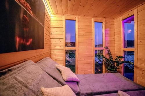 a bedroom with a bed in a room with windows at Relax Lodge (Eifel) in Hargarten
