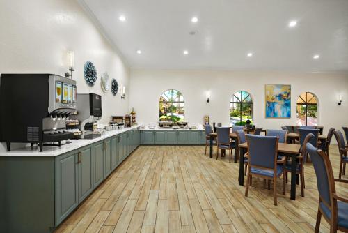 restauracja ze stołami i krzesłami oraz kuchnia w obiekcie La Fuente Inn & Suites w mieście Yuma