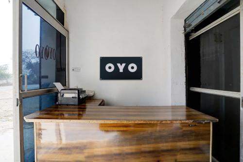 Jhājhar的住宿－Super OYO New River View，墙上有带 ⁇ 形标志的办公桌