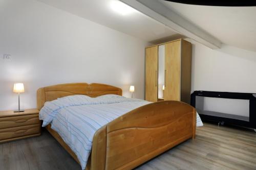 Gîte spacieux propre proche Gérardmer في Granges-sur-Vologne: غرفة نوم بسرير خشبي كبير وتلفزيون بشاشة مسطحة