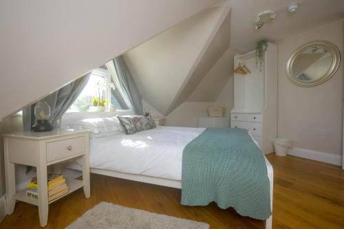 a bedroom with a white bed and a window at Entire Apartment in Central Brockenhurst in Brockenhurst