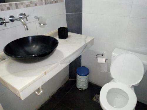 La salle de bains est pourvue d'un lavabo noir et de toilettes. dans l'établissement Casa Los Robles, à San Antonio de Arredondo