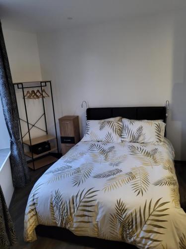 1 cama con edredón blanco con hojas de palmera en reve, en La Souterraine