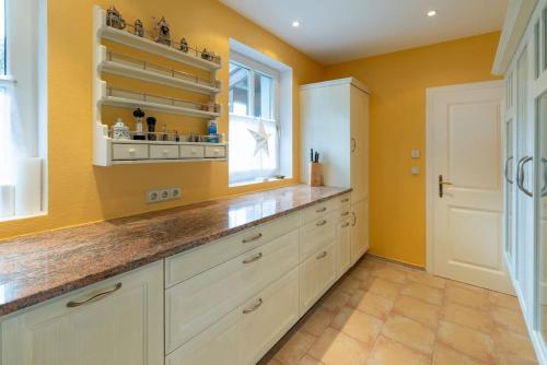 a kitchen with white cabinets and a window at Luxus Alpenparadies nahe Salzburg Sauna & Whirlpool in Adnet