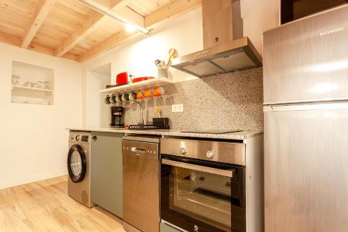 a kitchen with a stove and a refrigerator at Caserío El Ronzón in Camoca de Abajo