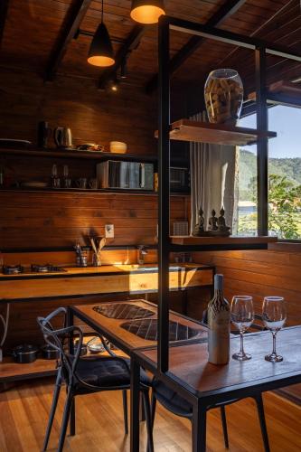 a kitchen with a table and two wine glasses at La Bella Vista in Urubici