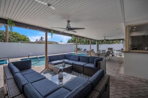 a living room with blue furniture and a swimming pool at Lauderdale By The Sea home in Fort Lauderdale
