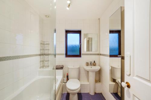 a bathroom with a toilet and a sink and a tub at Stylish 3 Bed House in Greenhithe in Greenhithe