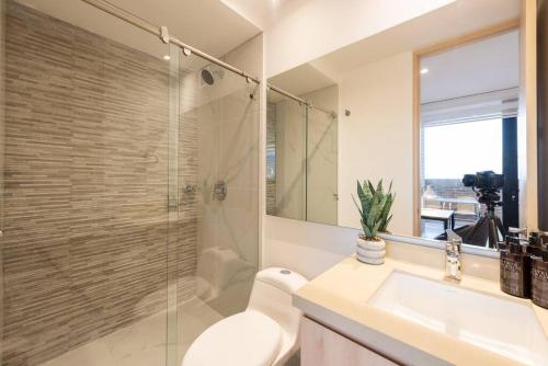 a bathroom with a sink and a glass shower at 1305 Hermoso apartamento para estrenar in Bogotá