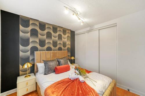 1 dormitorio con cama y pared en Stylish 3 Bed House in Greenhithe en Greenhithe