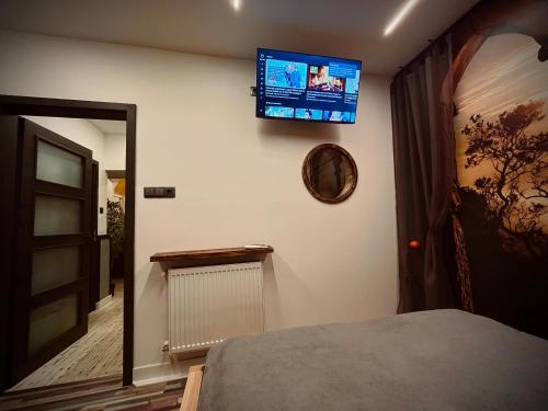 una camera da letto con TV a schermo piatto a parete di Friday’s apartman a Debrecen