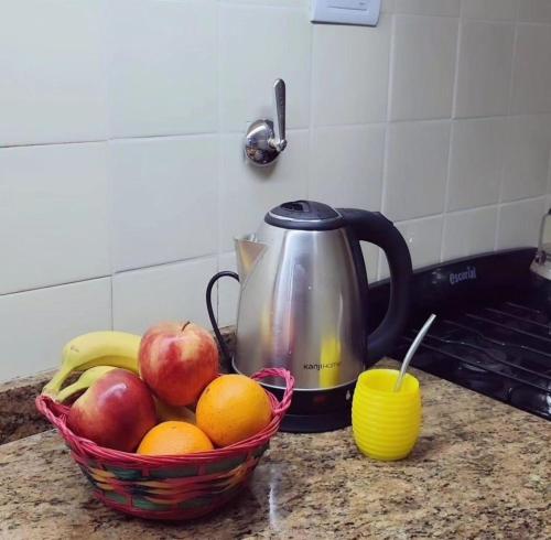 a basket of fruit on a counter with a tea kettle at Departamento Lo de Martha in Mar del Plata