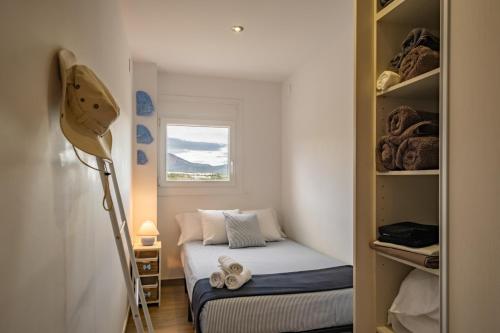 Habitación pequeña con cama y ventana en Apartamento con terraza, vistas playa y montaña, en Hospitalet de l'Infant