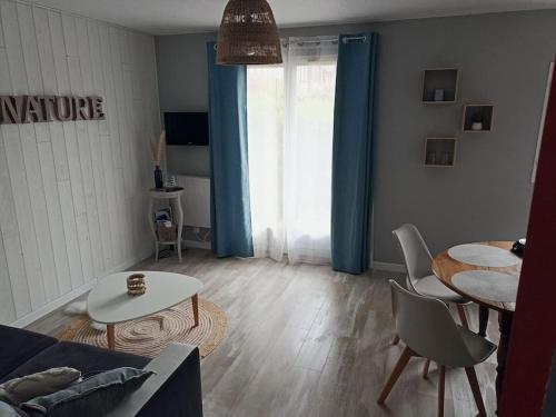 a living room with a couch and a table at Studio Cabourg - Home-Varaville avec jardin in Varaville