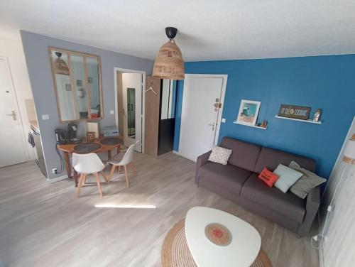 a living room with a couch and a table at Studio Cabourg - Home-Varaville avec jardin in Varaville