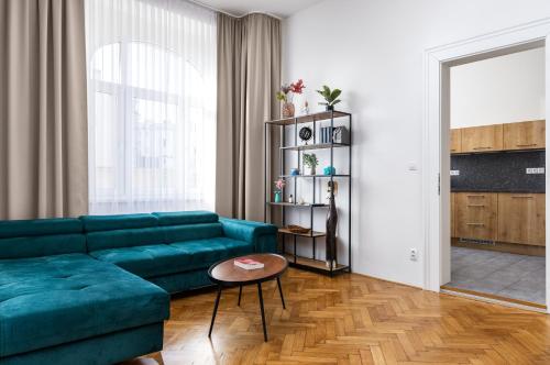 a living room with a green couch and a table at Stay2gether City Buzz Apt - O2 arena - Sleeps 6 in Prague