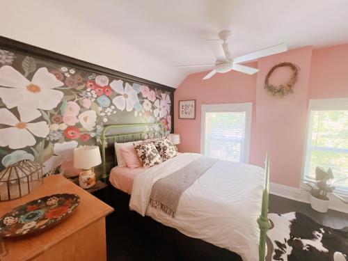 1 dormitorio con 1 cama con pared de flores en The River Farmhouse, en Corbyville