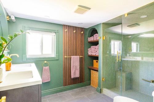 baño verde con lavabo y ducha en The River Farmhouse, en Corbyville