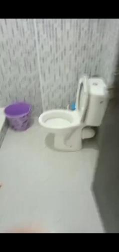 ein weißes WC im Bad mit einer lila Schale in der Unterkunft Samlalia home in Marrakesch