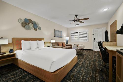 a bedroom with a large bed and a living room at La Fuente Inn & Suites in Yuma