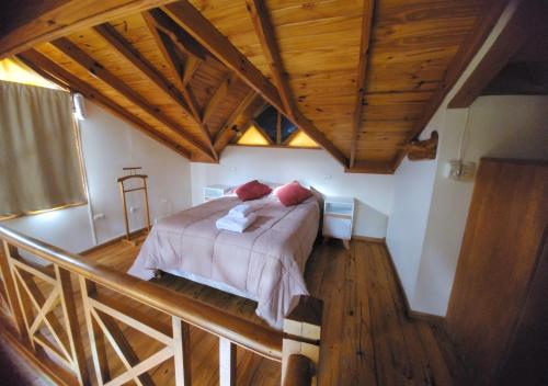 ein Schlafzimmer mit einem Bett in einem Zimmer mit Holzdecken in der Unterkunft La Barranca in Ushuaia