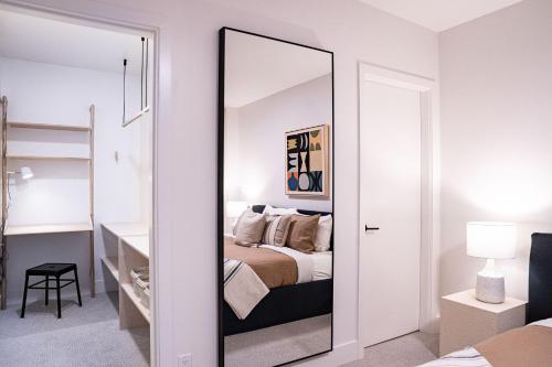 a mirror in a bedroom with a bed at Snow & Swing Getaway - Three Bedrooms with Hot Tub (Stay Revy) in Revelstoke