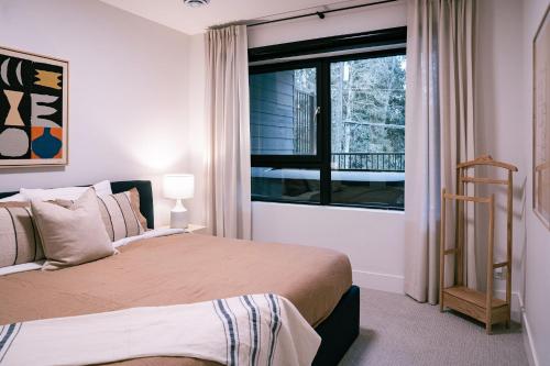 um quarto com uma cama grande e uma janela em Snow & Swing Getaway - Three Bedrooms with Hot Tub (Stay Revy) em Revelstoke