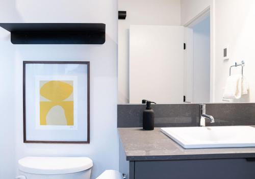a bathroom with a toilet and a sink at Snow & Swing Getaway - Three Bedrooms with Hot Tub (Stay Revy) in Revelstoke