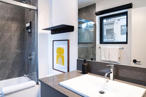 uma casa de banho com um lavatório e um espelho em Snow & Swing Getaway - Three Bedrooms with Hot Tub (Stay Revy) em Revelstoke