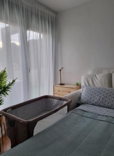 1 dormitorio con cama, sofá y ventana en La Casina Del Alce, en Aller