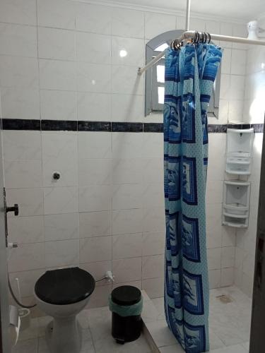 La salle de bains est pourvue de toilettes et d'un rideau de douche. dans l'établissement Casa de Praia em São Pedro da Aldeia, à São Pedro da Aldeia