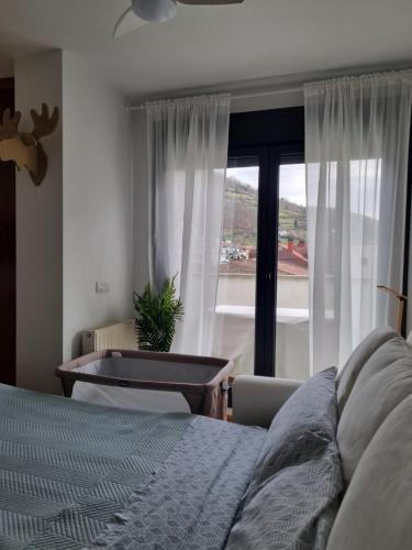 1 dormitorio con cama y ventana grande en La Casina Del Alce, en Aller
