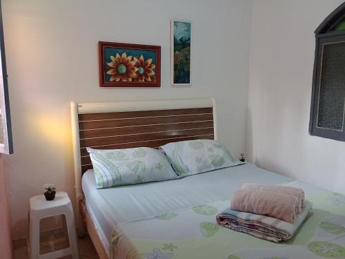 - une chambre avec un lit et une tête de lit en bois dans l'établissement Casa de Praia em São Pedro da Aldeia, à São Pedro da Aldeia