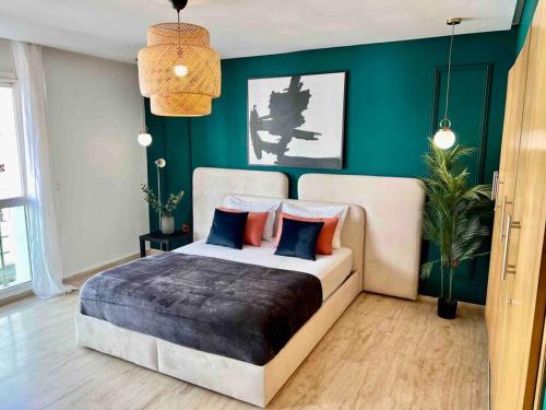 - une chambre avec un lit et un mur vert dans l'établissement Luxurious 1bd room apartment in Agdal Rabat city, à Rabat