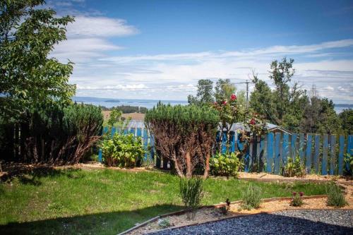 a garden with a blue fence and some plants at Cabaña con vista al Lago in Ranco