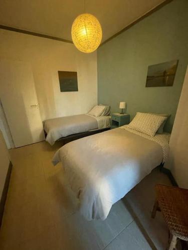 a bedroom with two beds and a chandelier at Daloba House in Costa da Caparica