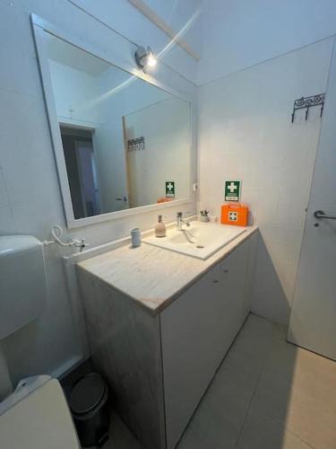 a bathroom with a sink and a mirror at Daloba House in Costa da Caparica