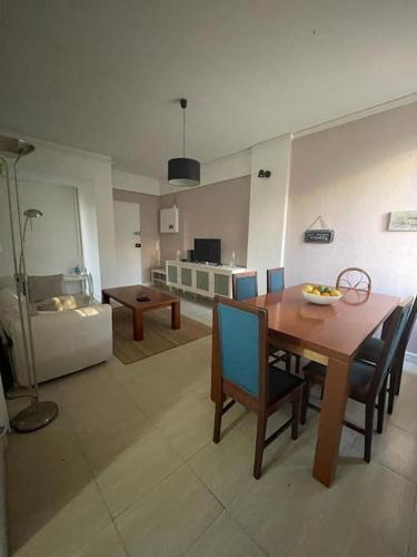 a living room with a wooden table and chairs at Daloba House in Costa da Caparica