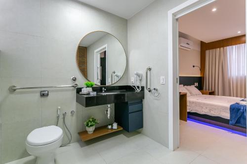 een badkamer met een wastafel, een toilet en een bed bij Studiopcdfloripa in Florianópolis