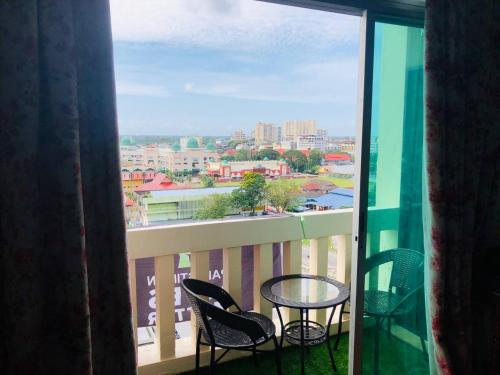 a balcony with a table and chairs and a view of a city at Studio Apartment KTC KB in Kota Bharu