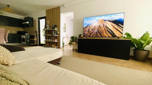 ein Wohnzimmer mit einem Großbild-TV an der Wand in der Unterkunft Big House Adeje Deluxe by Deihu Experiences in Adeje